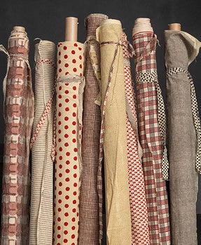 Collection of fabric rolls with various patterns and colors on a black background